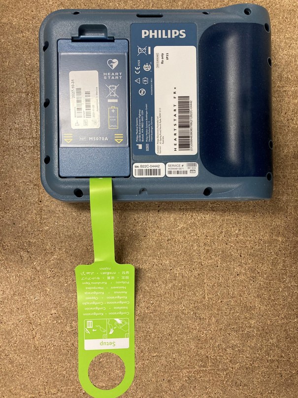Green tab on the back of the Philips FRx for battery removal