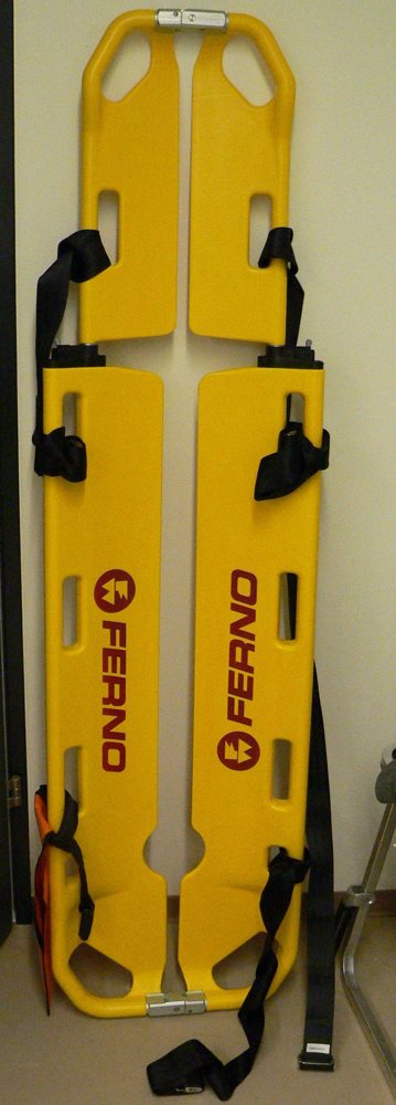 Yellow scoop stretcher with its two halves joined and straps attached